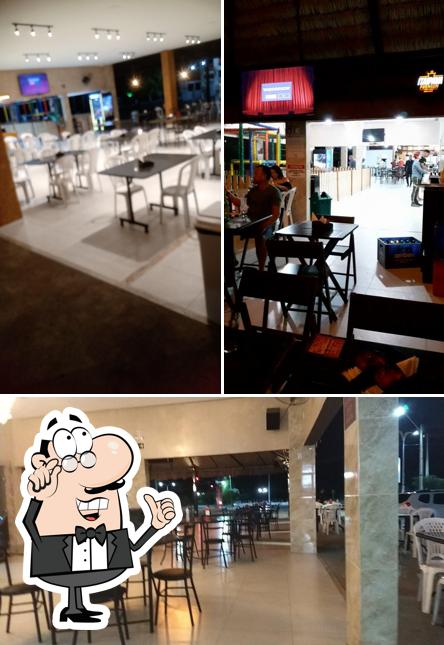 Sente em uma das mesas no Palhoça Grill