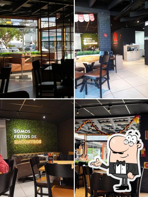 Sente em uma das mesas no Quiero Café