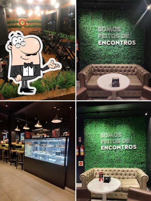 Sente em uma das mesas no Quiero Café